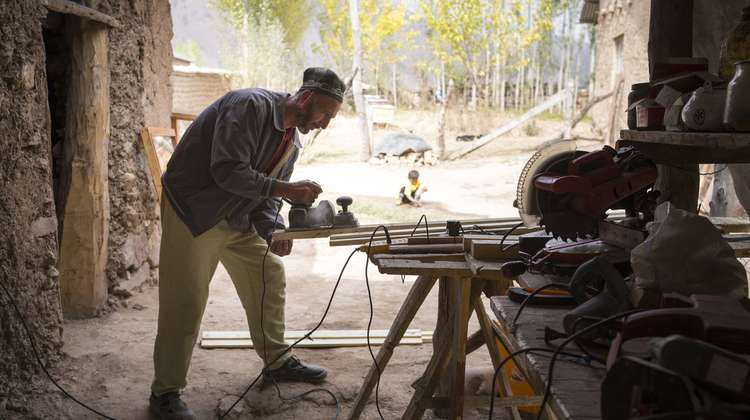 Der Fensterbauer Ilhom Jatimov arbeitet auf dem Hof seines Wohnhauses in Sari Hussor, Tadschikistan am 18.10.2016. Den Strom gewinnt er durch einen vom Fluß abgeleiteten Wasserkanal, der eine Turbine betreibt und Strom für den Haushalt und die Werkstatt liefert.