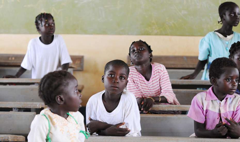 Hilfe für Kinder in Burkina Faso. Bildbeschreibung: Kinder sitzen hintereinander in Schulbänken