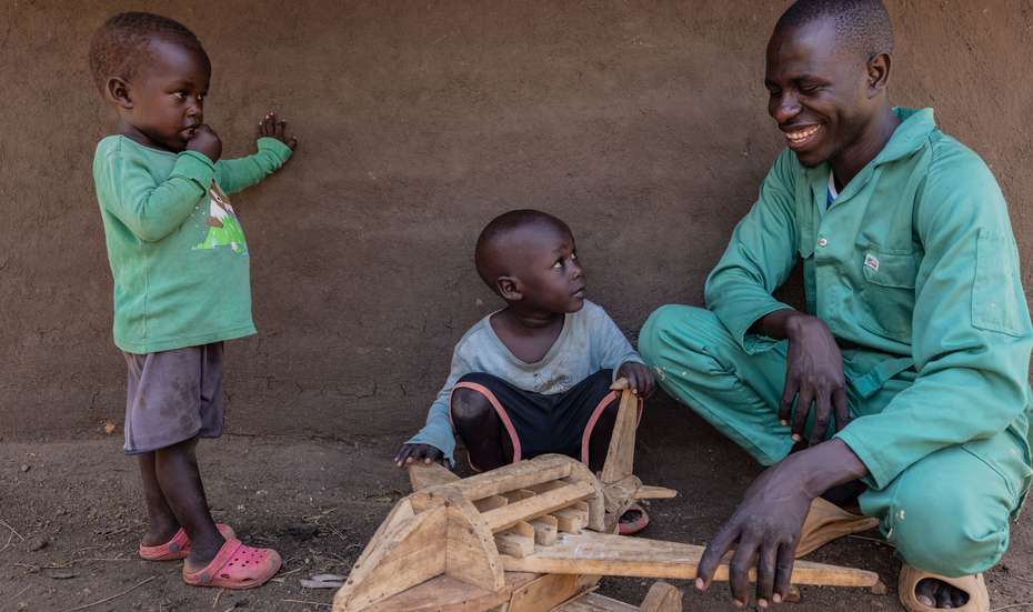 Uganda: Der neu ausgebildete Schreiner Francis Lukuyu, 25, zeigt seinen kleinen Neffen Keni, 5, und Bebe seinen Holzhobel