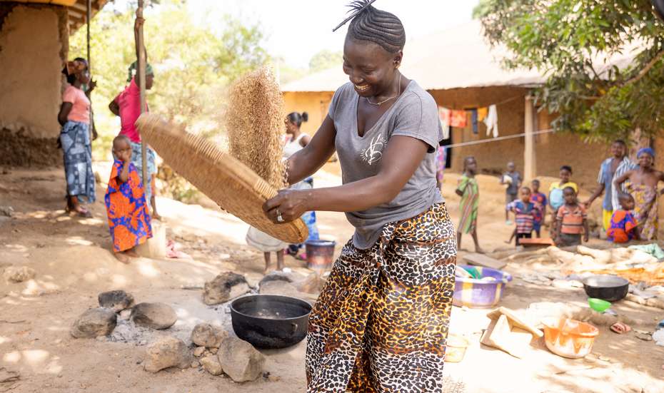 Im Dorf Giehun in der Kenema-Provinz in Sierra Leone schwenkt Massah Turay auf einem Sieb Reiskörner. 