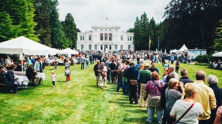 Foto der Villa Hammerschmidt in Bonn bei einem Tag der offenen Tür, viele Menschen versammelt auf dem Rasen vor dem Eingang
